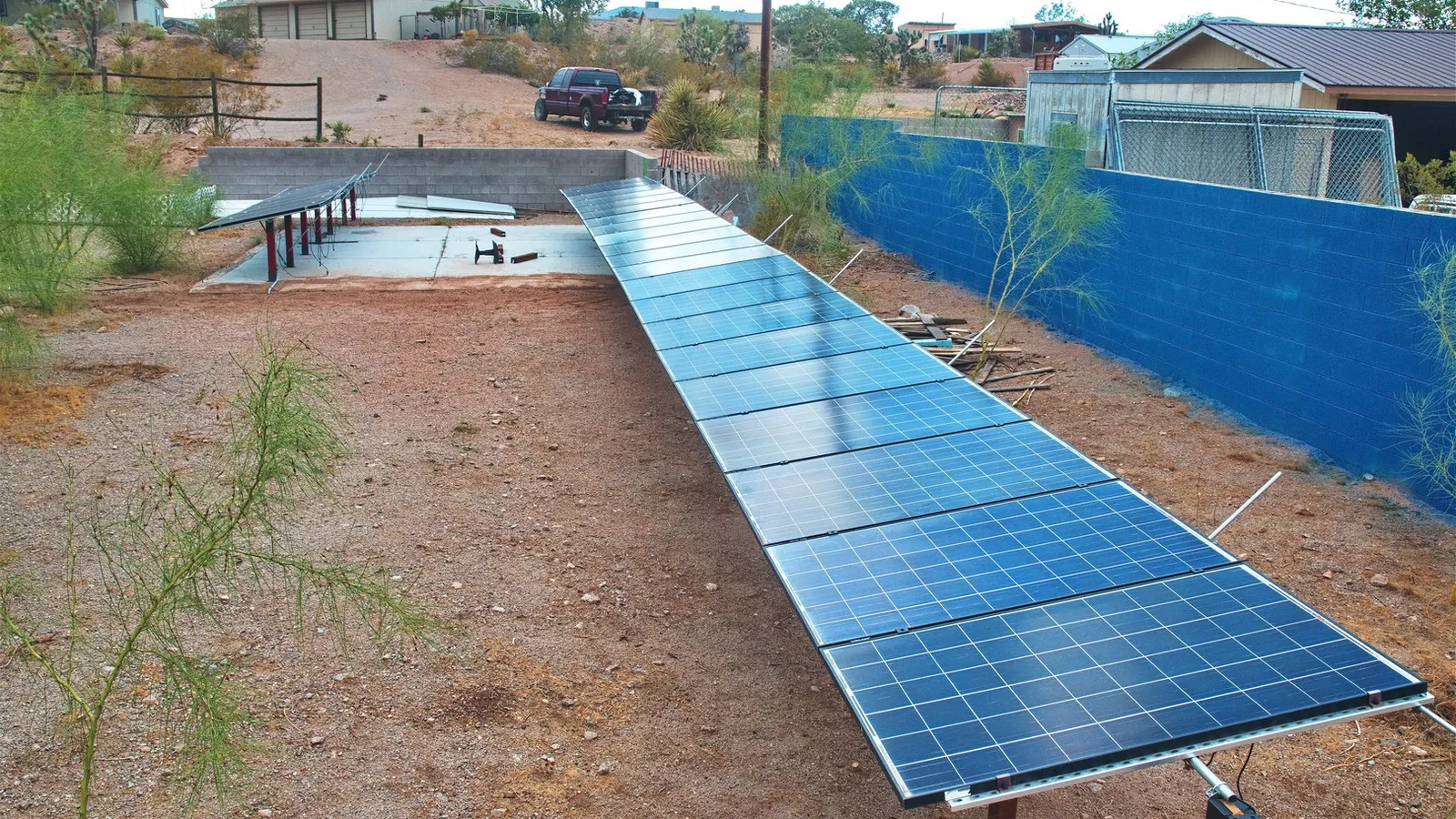 July 2024 a wash flows beneath the panels and panels provide shade for plants to grow.